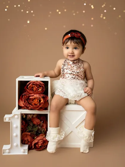 Posing like a pro. This little girl is perfectly at home in her beautiful first birthday setup, creating a portrait her parents will treasure.