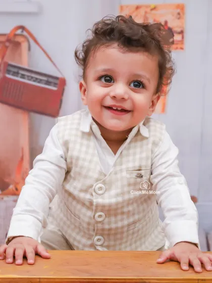 A bright, happy smile from our little student. The vintage props in the background add a charming, timeless feel to this toddler portrait.