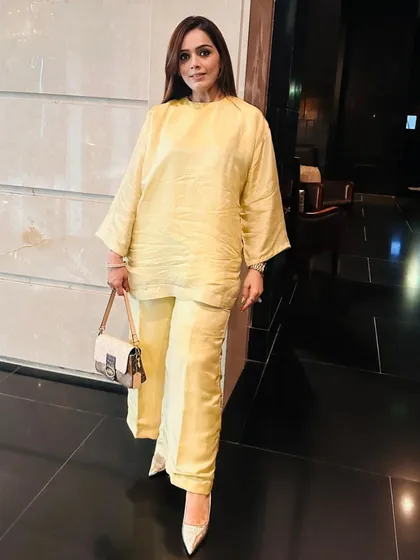 A full-length look at the yellow choga set, showing how the clean lines and bright color create an effortlessly stylish ensemble. It's a versatile piece that can be dressed up or down.