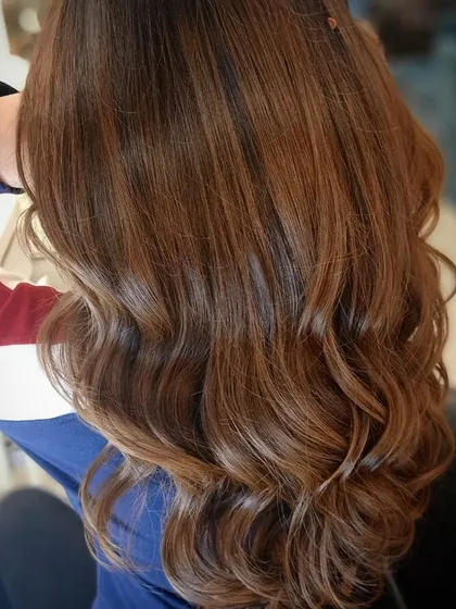 A close-up of the warm caramel hair color, showing the beautiful shine and healthy condition of the hair after our coloring service.