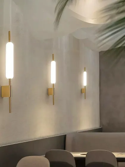 A row of linear wall sconces in a restaurant setting. This shows how simple fixtures can be used to create a high-end, cohesive look.