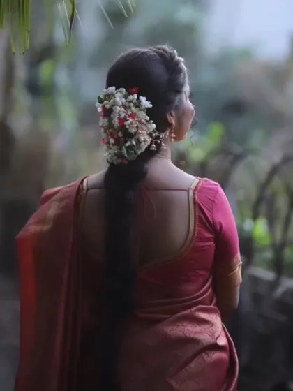 The back view of a bride, highlighting the beautiful gajra (floral arrangement) in her hair, a signature element of the South Indian bridal look.