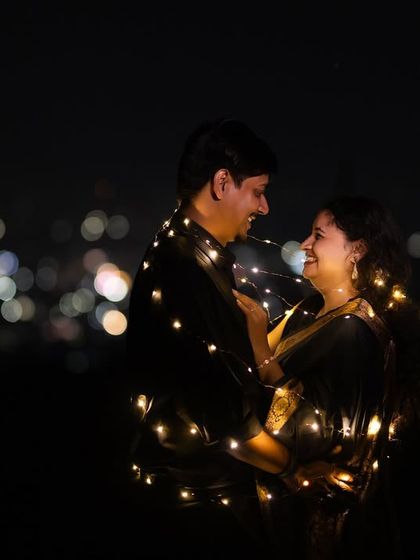 A romantic embrace wrapped in fairy lights, with the city lights creating a beautiful bokeh background. This is a simple yet stunning way to create a magical night portrait.