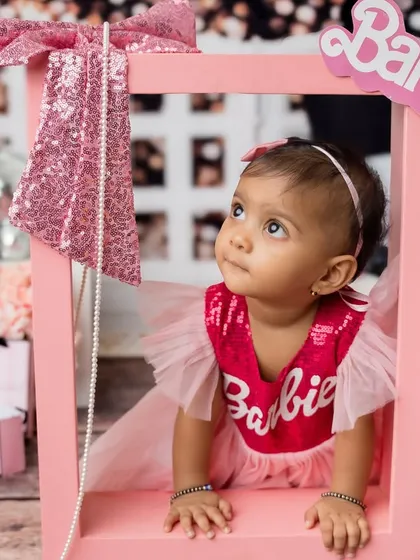 The youngest sister peeking through a Barbie box prop. I love using creative props in sibling photoshoots.
