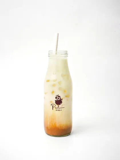 A bottled iced coffee drink from 'Protein Bowls', shot against a pure white background. This minimalist style is effective for e-commerce and beverage menu photography, focusing on the product and branding.
