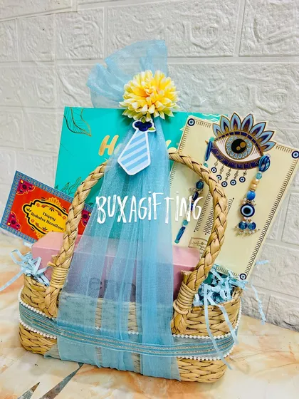This Bhai-Bhabhi Rakhi hamper is all about the details, from the tiny tie cutout to the evil eye rakhi and matching blue decorations.