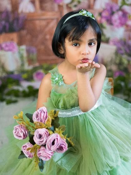 Blowing a kiss to the camera. This playful and sassy pose perfectly captures the personality of this little girl in her green dress.
