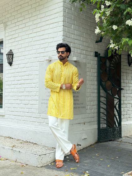 Our festive yellow kurta, worn here without a jacket for a more casual yet equally stylish look. The intricate pattern and bright color make it a standout piece for any celebration.