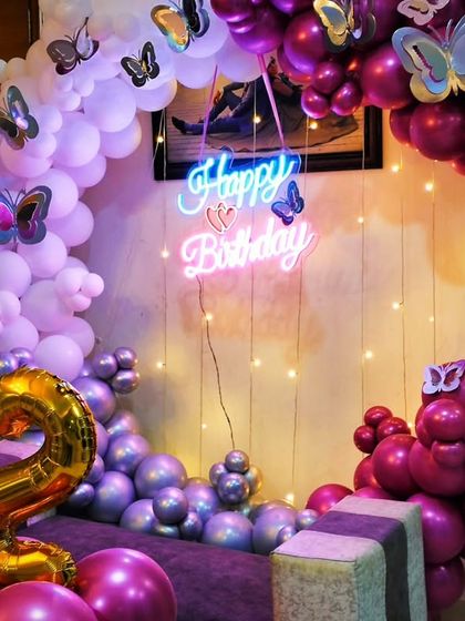 A close-up of a 32nd birthday setup, focusing on the details like the champagne bottle balloon and the mix of chrome and pastel balloons.