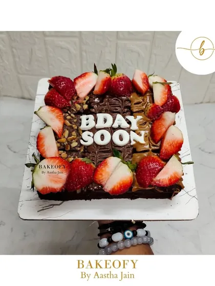 A beautiful brownie slab decorated with Nutella drizzle, fresh strawberries, and walnuts. This is a perfect treat for a birthday or any celebration, combining rich chocolate with fresh fruit.