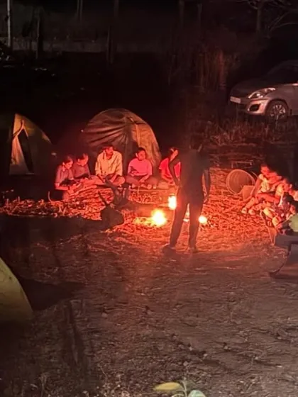 Our campsite at night, with tents pitched and trekkers gathered around a crackling campfire. This is the perfect end to a day of hiking.