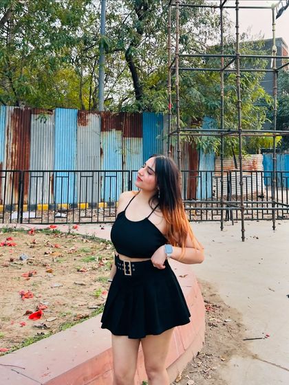 A thoughtful pose in the black dress. The outdoor, slightly gritty background contrasts nicely with the cute outfit.