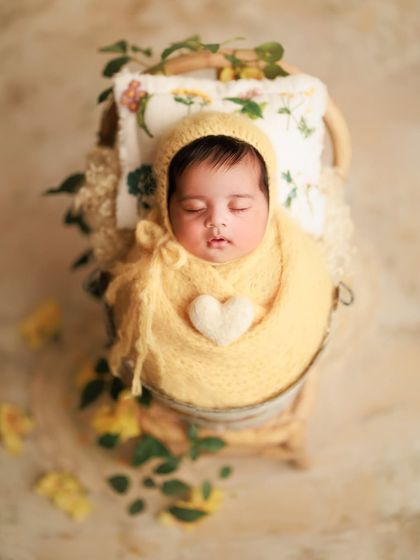 A tender glow for this 7-week-old beauty. The warm yellow wrap and bonnet, combined with a little felt heart, create a sunny and joyful portrait.