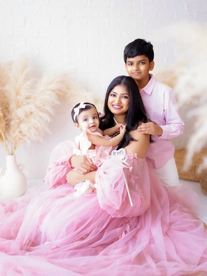 Welcoming a new baby is a joy for the whole family. This portrait captures a proud big brother with his mom and new baby sister.