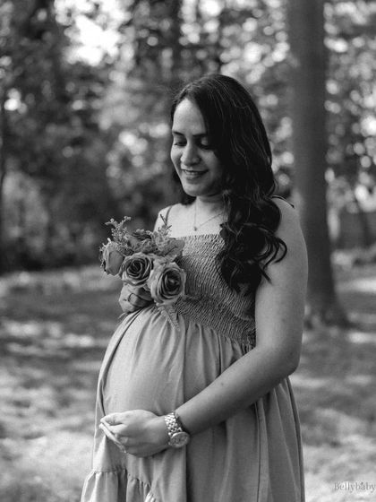 A timeless black and white portrait holding a bouquet of roses. The natural park setting and the classic feel of monochrome create a beautiful, romantic image.