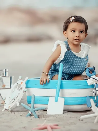A curious little sailor looking out from her boat. The beach provides a wonderful natural setting for these creative and fun photoshoots.