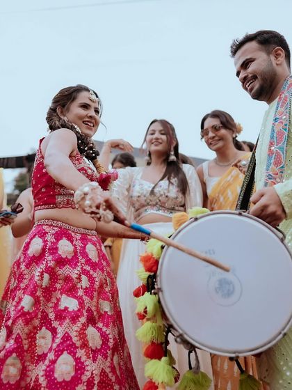 The bride having fun with the dhol. Her energy is infectious, and she looks absolutely stunning.