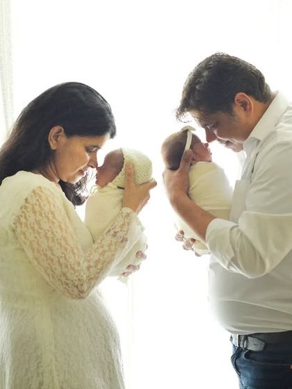 Capturing newborn twins is a special joy. This photo shows the new parents each holding one of their babies, creating a beautiful, symmetrical, and heartfelt family portrait.