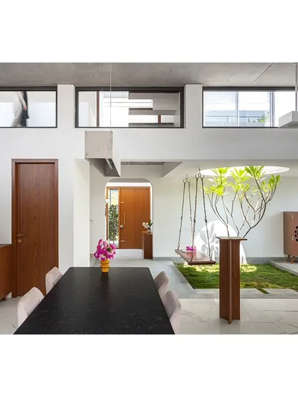 The open-plan dining and living area is defined by an internal courtyard. This layout creates distinct functional zones without using solid walls, maintaining a sense of openness and flow throughout the ground floor.