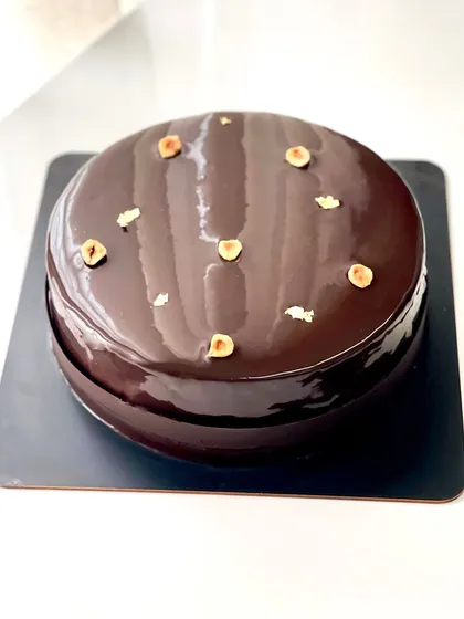 A rich and decadent entremet for a 50th birthday celebration. This one features layers of chocolate brownie, toasted hazelnut cremeux, and dark chocolate mousse, all covered in a shiny dark chocolate glaze.