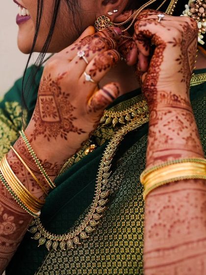 A candid shot of the bride, where the beautiful henna stain on her hands and arms adds to her overall look.