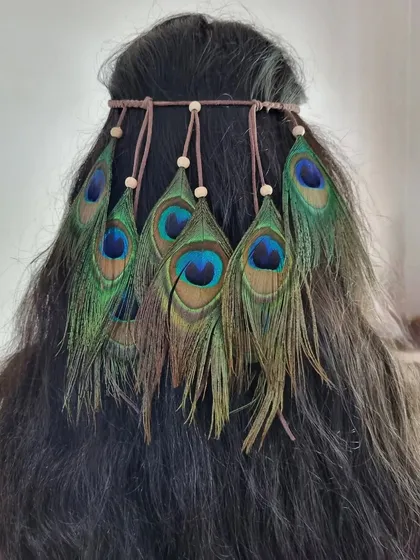 Unleash your inner bohemian goddess with our peacock feather headband. The natural iridescence of the feathers makes this a truly eye-catching hair accessory.