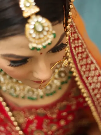 A top-down shot emphasizing the bride's intricate maang tikka and stunning eye makeup. This angle provides a unique perspective on the bridal details and makeup artistry.