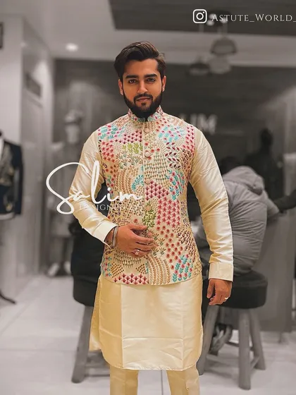A client in a cream-colored kurta paired with a multi-colored embroidered Nehru jacket. The vibrant jacket adds a festive touch to the classic kurta set.