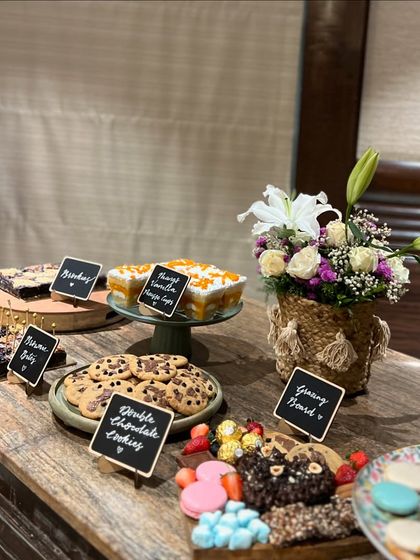 A view of one of our dessert tables, featuring brownie bites, double chocolate cookies, mango vanilla mousse cups, and a grazing board. Everything is homemade and can be customized for your event.