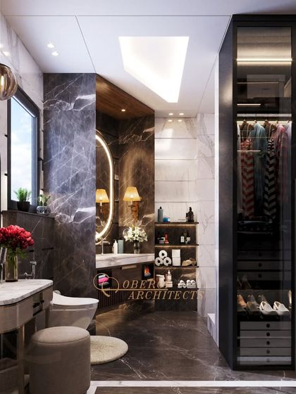 The view towards the walk-in closet with glass doors shows how we seamlessly integrate storage solutions into our bathroom designs for a cohesive and practical layout.