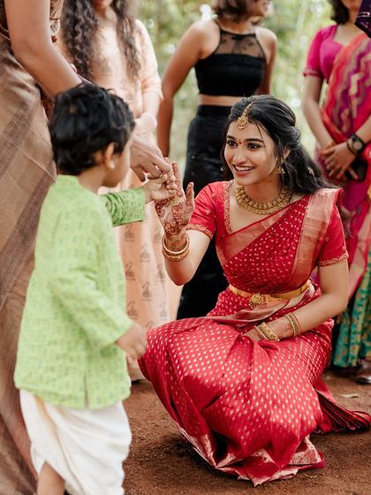 A heartwarming moment between the bride and a young guest. Her makeup is fresh and approachable, making her look radiant and friendly.