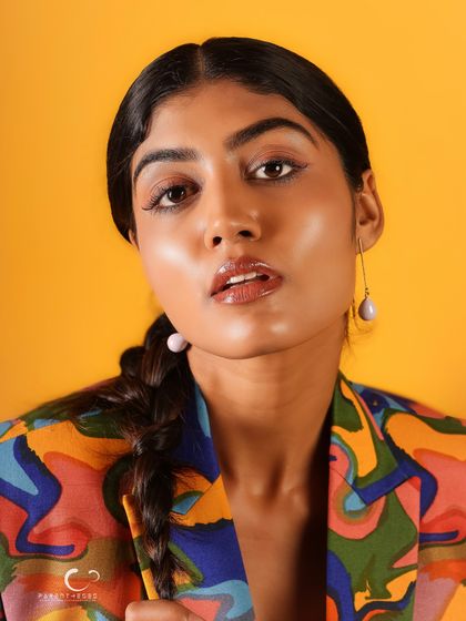 A slightly softer expression in this close-up, showing a different side of her personality while still rocking the bold, artistic suit.