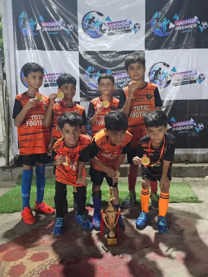 The U9 champions of the Andheri Premier League proudly showing off their medals and trophy.