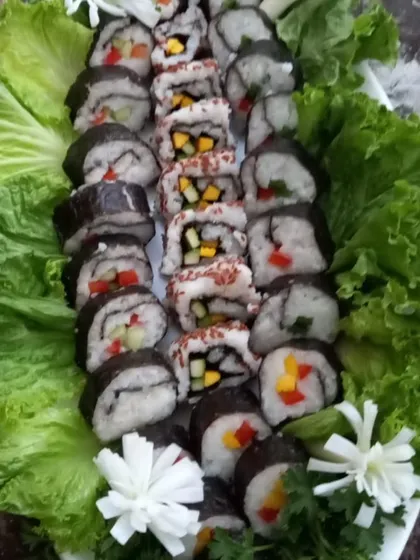 A platter of my handcrafted vegetarian sushi, beautifully presented on a bed of fresh lettuce. This is part of my fusion catering menu, offering a taste of global cuisine made with 100% vegetarian ingredients.