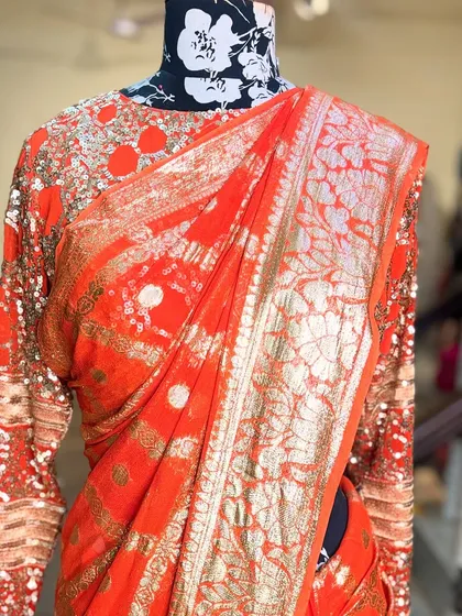 A detailed shot of the golden floral work on the 'SONDARYA' saree. This traditional motif is given a modern feel, making it perfect for today's woman.