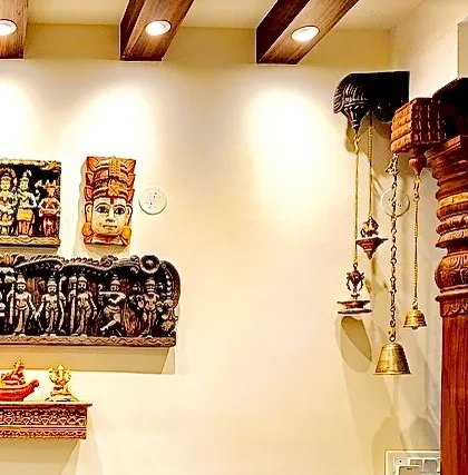 A close-up of the wall from image 206, showing the intricate details of the wooden carvings and hanging brass bells.