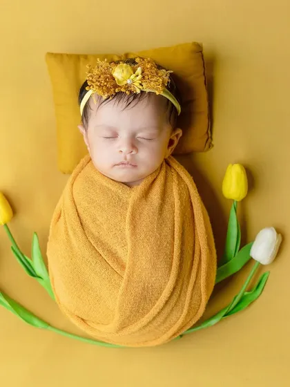 A simple and sweet setup with tulips framing the swaddled newborn.