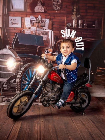 Sun's out, guns out! This little biker is ready to ride, looking cool and confident on his miniature motorcycle in the vintage garage set.