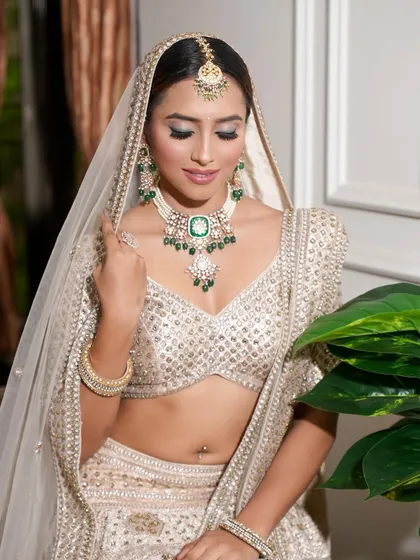 A demure bridal pose. The soft makeup and sleek hair bun create a look of pure elegance and sophistication.