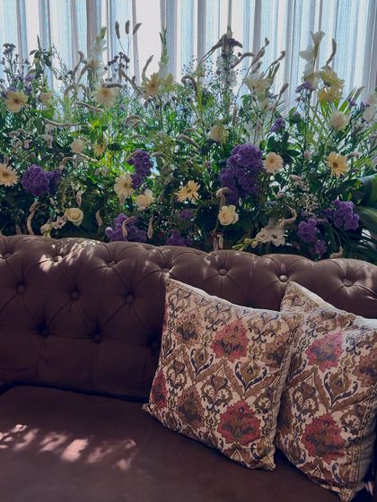 A long shot showing how we use large floral arrangements to create a backdrop behind seating areas. This not only looks beautiful but also helps to define the space.