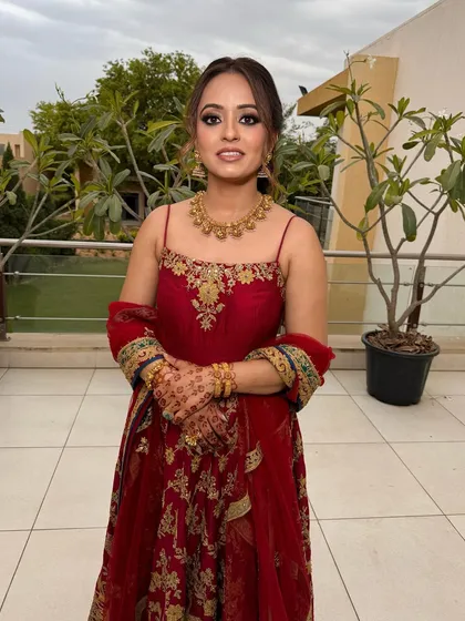 A full view of this fairy-like look. The makeup is soft and glowing, with a focus on the eyes, letting her red outfit and detailed hairstyle shine.
