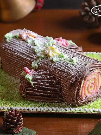 Our colourful Yule Log cake, decorated with buttercream flowers. This festive roll cake is a beautiful and delicious addition to any Christmas party table.