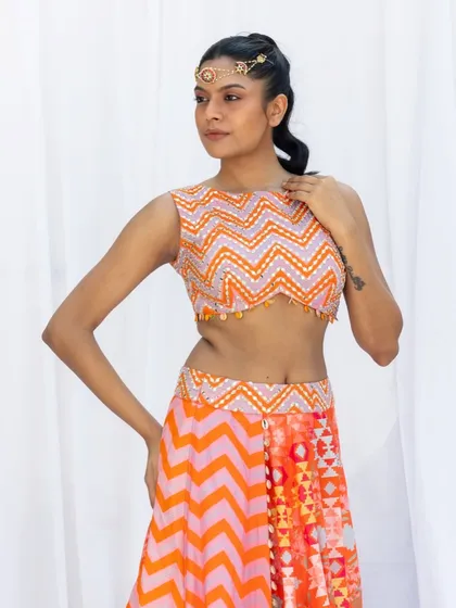This three quarter shot captures the full outfit, including the patterned top and vibrant skirt. The model's pose is natural yet deliberate, showcasing the flow and fit of the clothing for an e-commerce or catalog feature.