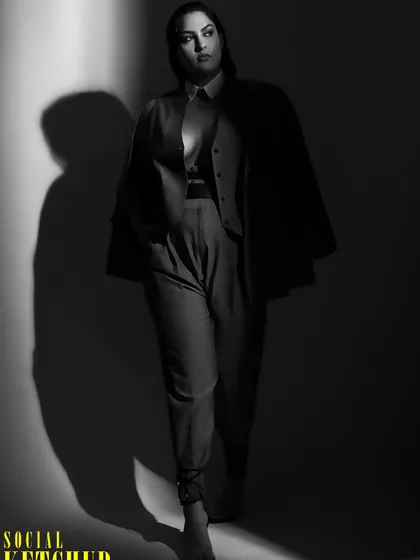 A moody, atmospheric shot from the Social Ketchup editorial. The play of light and shadow highlights the structure and tailoring of the outfit.