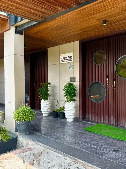 The entrance to the architect's studio, where potted plants and a simple green mat create a welcoming and grounded entryway.