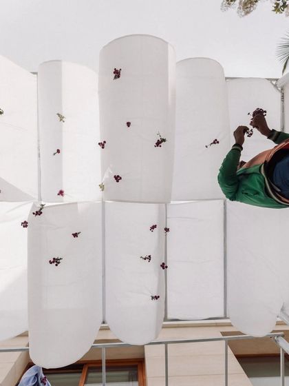 A behind-the-scenes shot of our team stitching flowers onto the organic fabric canopies for the sustainable engagement.