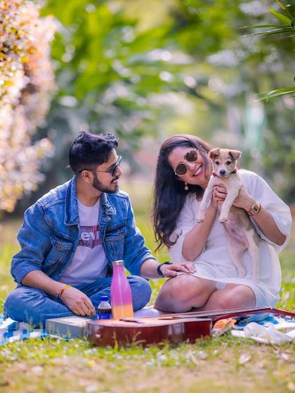 A perfect picnic scene in a grassy meadow, complete with a guitar and a furry friend, showcasing a relaxed and casual photoshoot concept.