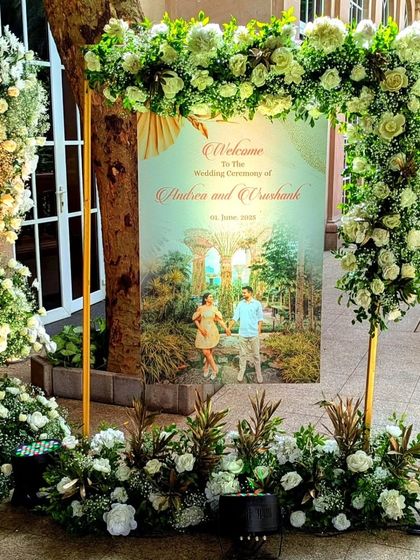 To make the welcome truly personal, I incorporated the couple's pre-wedding photo into the signage. The custom sign is framed by an elegant arch of white and green florals, connecting their love story to the celebration.