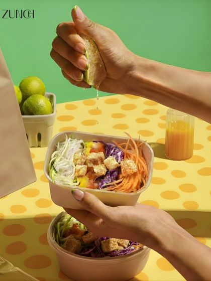 A final squeeze of lime over our Thai Me Up bowl. This action shot captures the freshness and bold flavors that make this meal so special.