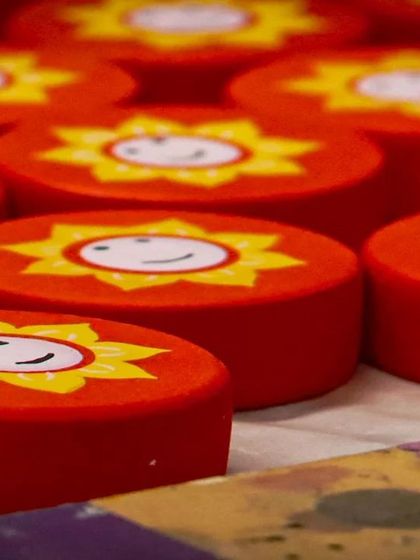 These cheerful, smiling sun discs are components for a larger toy. The bright, happy faces are painted by hand, and the vibrant red is derived from natural pigments, making them completely safe for children.